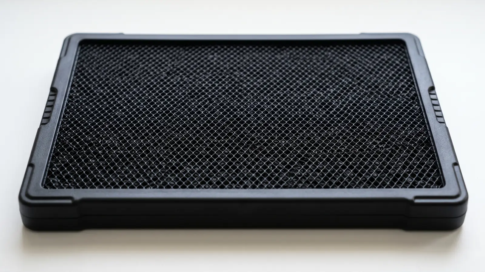 Activated carbon air purifier filter with carbon granules visible through the mesh layer