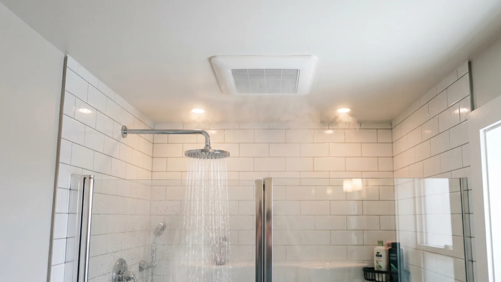 Bathroom exhaust fan pulling steam from a tiled shower, venting moisture to prevent mold growth