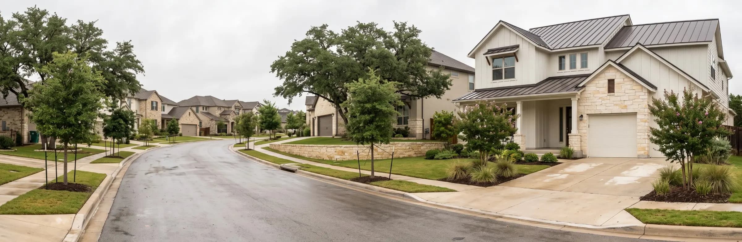 Large two-story modern farmhouse style home with limestone accents on a residential street lined with live oaks in Austin, Texas