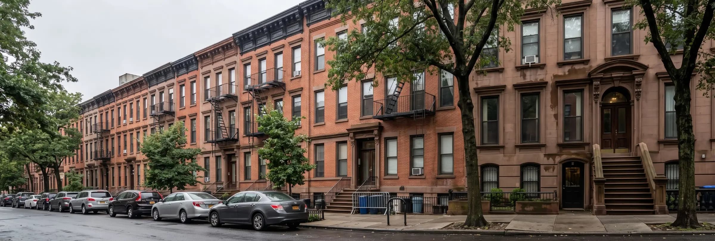 Brownstone row house with a front stoop and garden level entrance on a tree-lined Brooklyn street in New York City