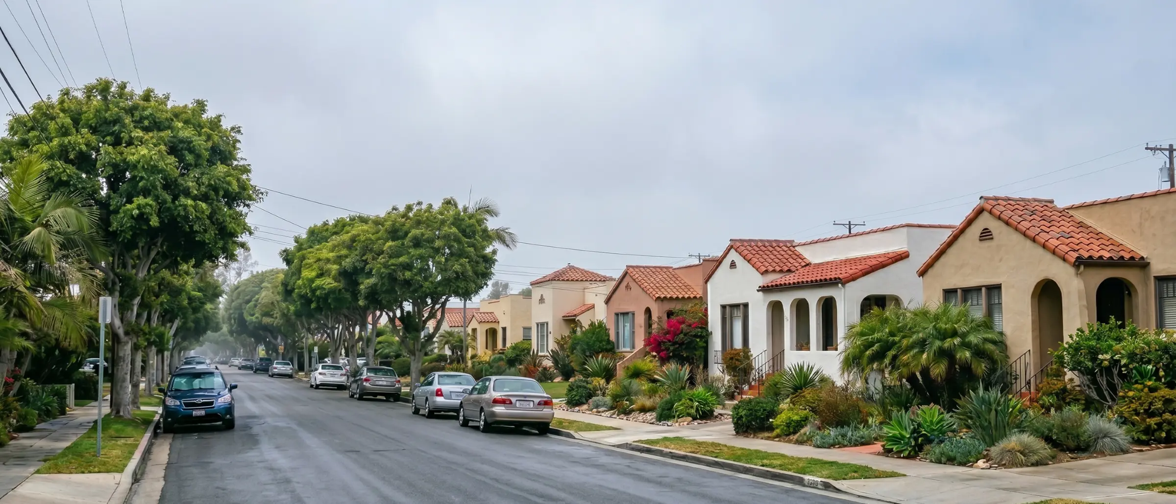 Foggy coastal San Diego street with stucco homes and clay tile roofs under marine layer clouds